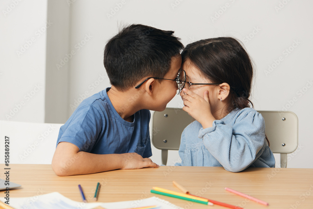 small children sit together at the table and communicate with each other small children sit together at the table and communicate with each other