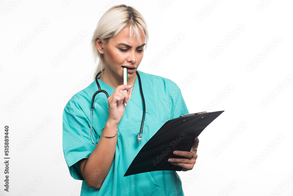 Female doctor trying to write something on clipboard with pen on white background Female doctor trying to write something on clipboard with pen on white background
