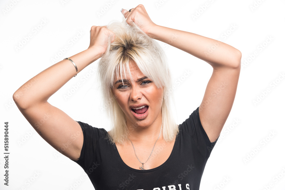 Fototapeta premium Young woman pulling out her hair on white background