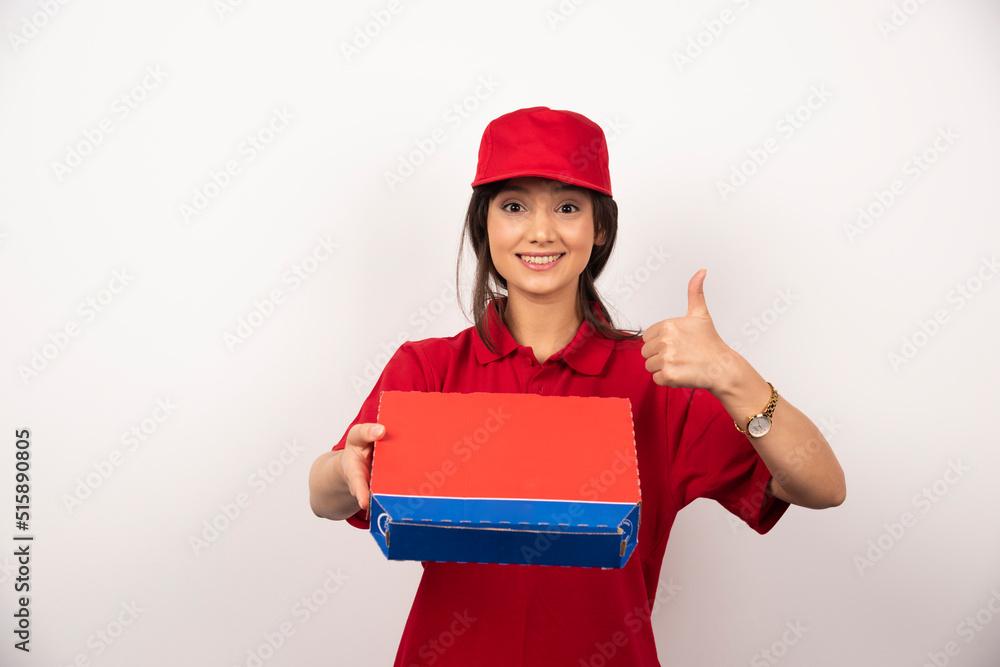 Young smiling woman in red uniform delivering pizza in box Young smiling woman in red uniform delivering pizza in box