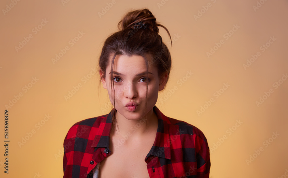 Portrait of funny childish woman send fun air kiss boyfriend valentine day date, celebration wear red n checkered shirt isolated over yellow background Portrait of funny childish woman send fun air kiss boyfriend valentine day date, celebration wear red n checkered shirt isolated over yellow background