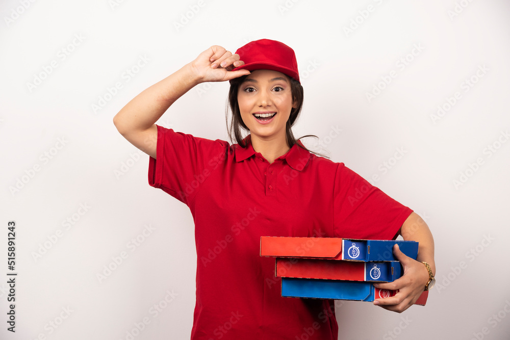 Happy female pizza delivery worker standing in white background with three cardboards of pizza Happy female pizza delivery worker standing in white background with three cardboards of pizza