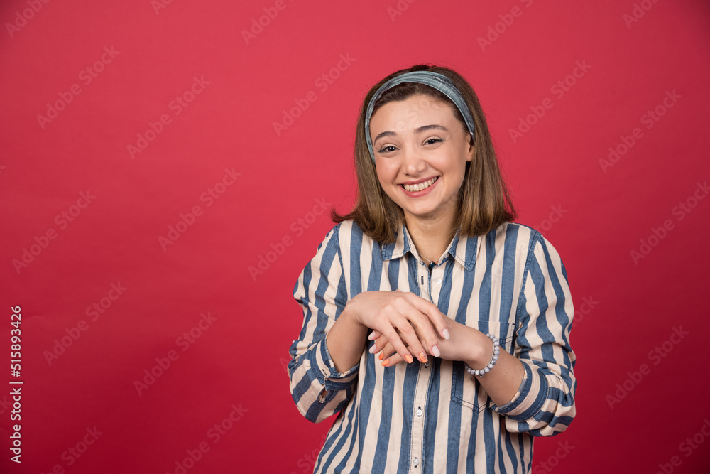 Short haired girl smiling sheepishly on red background Short haired girl smiling sheepishly on red background