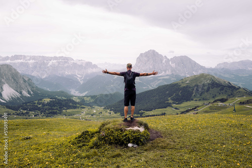 Man standing on the top of the rock overlooking the mountain view