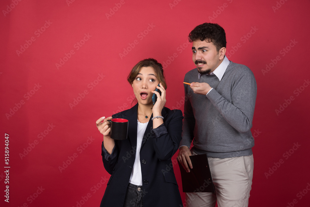A young woman talking on smartphone near angry boyfriend