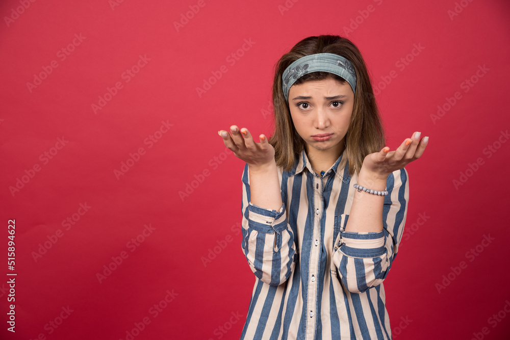 Adorable girl standing on red background with open hands Adorable girl standing on red background with open hands