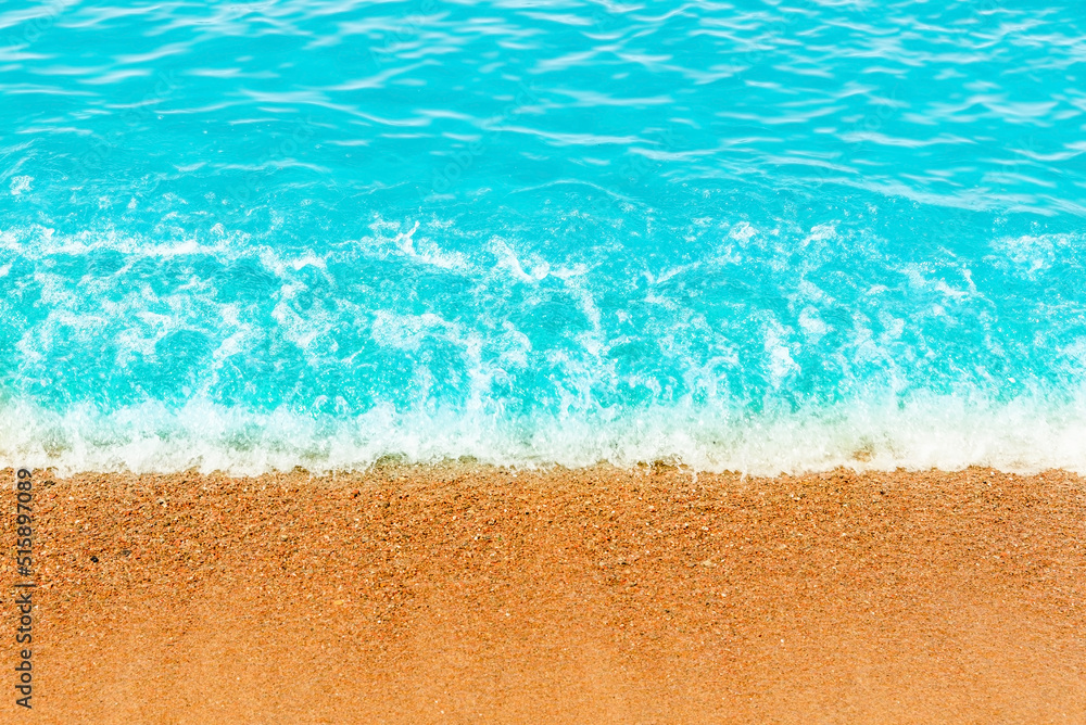 Obraz premium Blue sea wave,golden sand beach,white foam,turquoise ocean water.Close-up.Summer holidays concept.Tropical island vacation backdrop,tourist travel banner design template, copy space.