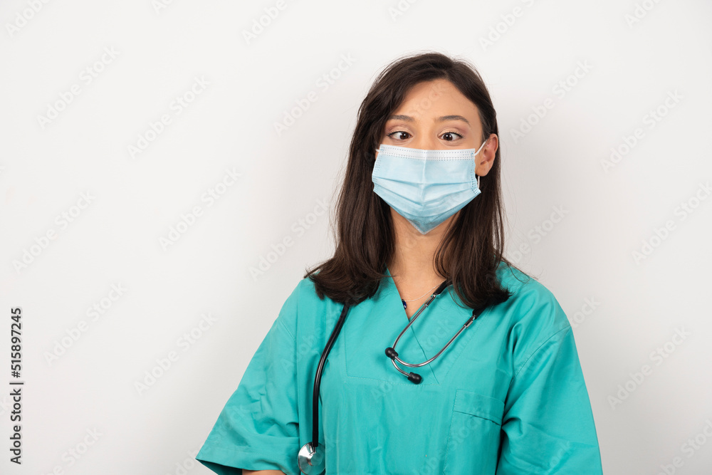 Young doctor with medical mask standing on white background Young doctor with medical mask standing on white background