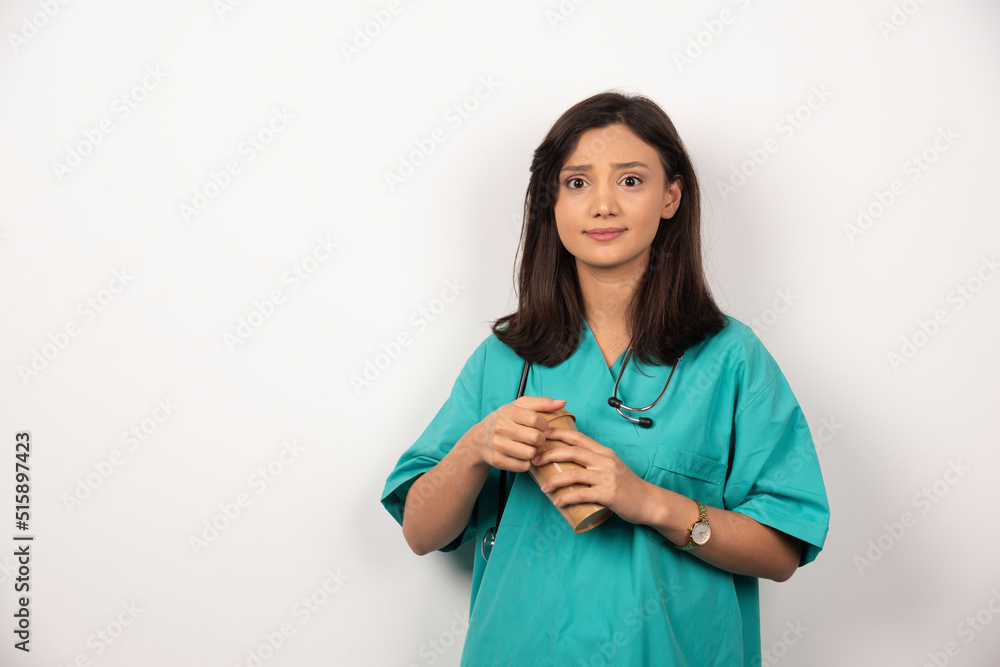 Female doctor with stethoscope holding cup on white background Female doctor with stethoscope holding cup on white background