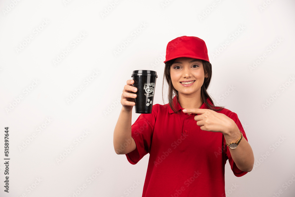 Woman in red uniform showing a cup of coffee on white background Woman in red uniform showing a cup of coffee on white background