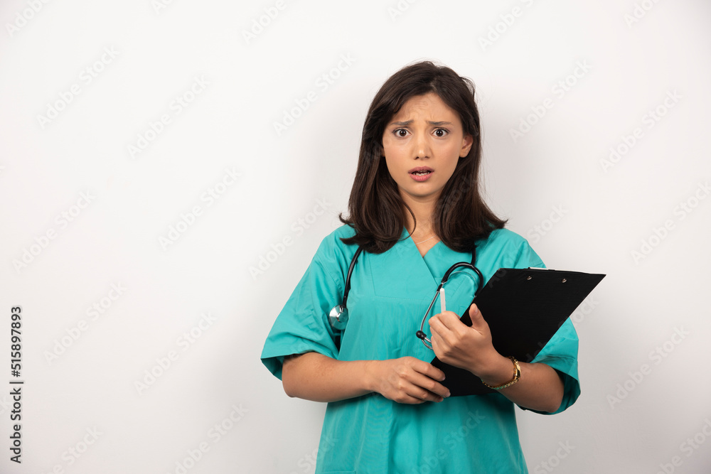 Woman doctor with stethoscope holding clipboard on white background Woman doctor with stethoscope holding clipboard on white background