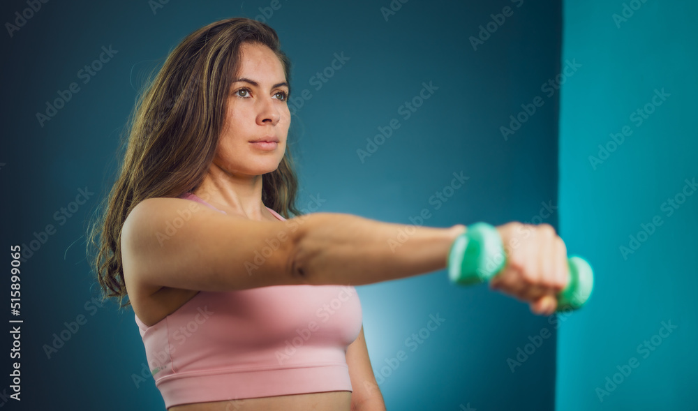 woman in the gym lifting weights and posing for the camera woman in the gym lifting weights and posing for the camera