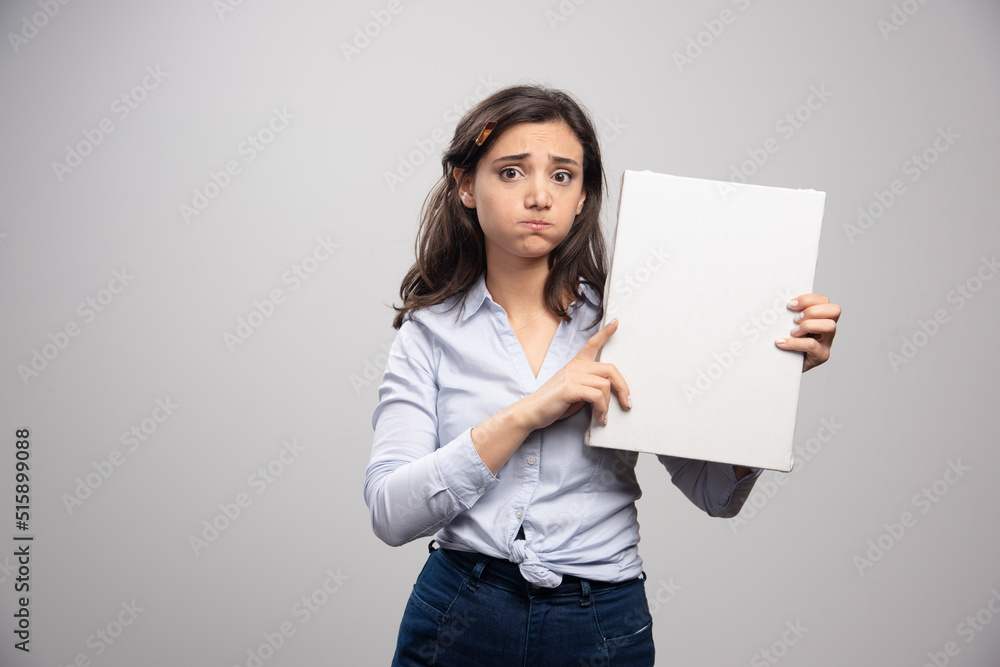 Brunette painter holding canvas and sulking Brunette painter holding canvas and sulking