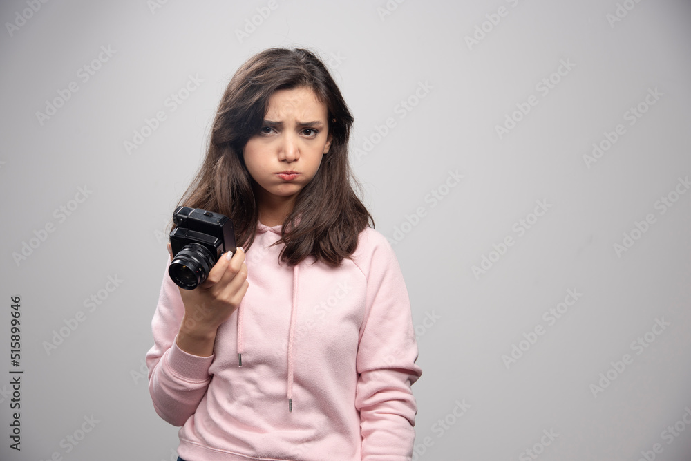 Young woman with camera feeling sad Young woman with camera feeling sad