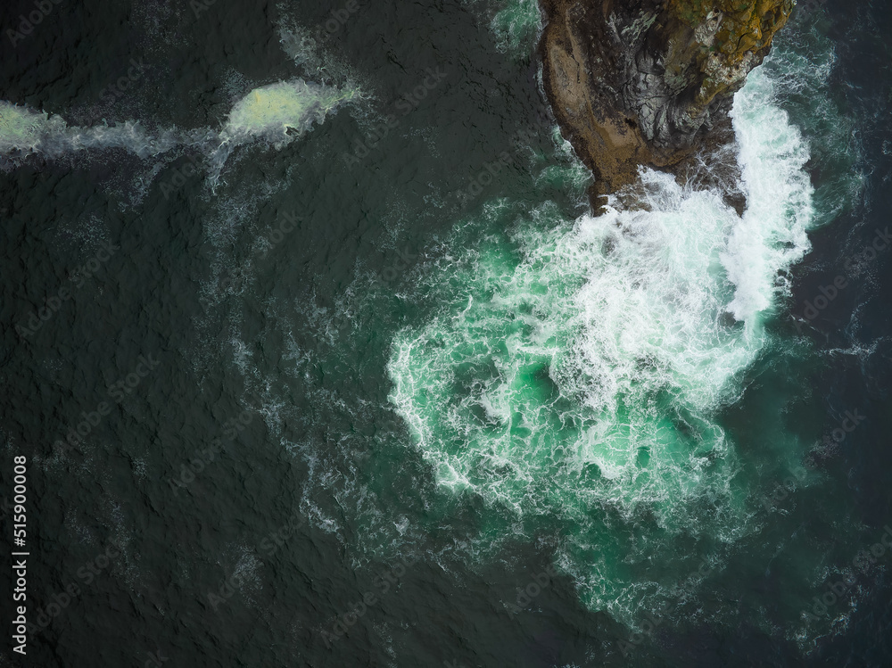 Shooting from the air. Turquoise water of the ocean, white foamy waves crashing against the rocky shore. Abstraction. The beauty and majesty of nature. Environmental Protection. Shooting from the air. Turquoise water of the ocean, white foamy waves crashing against the rocky shore. Abstraction. The beauty and majesty of nature. Environmental Protection.