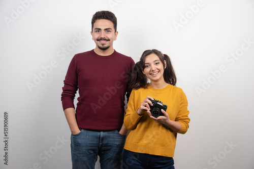 Man standing nearby young woman with camera