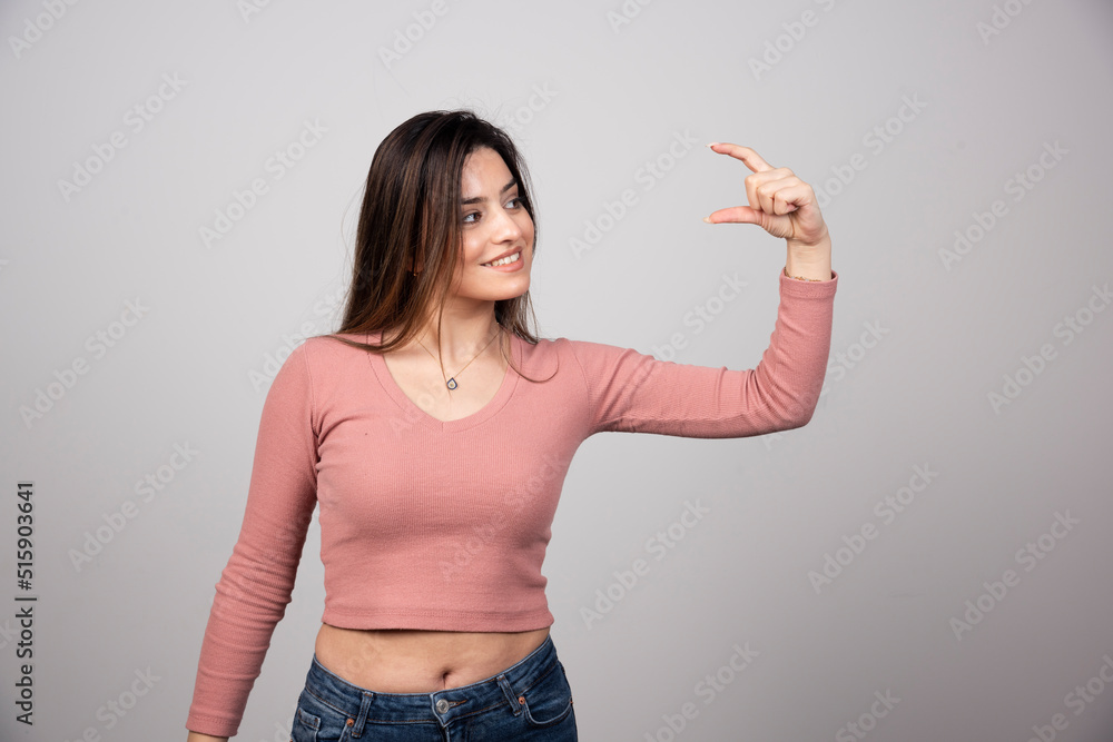 A young woman showing something small in size with hands A young woman showing something small in size with hands