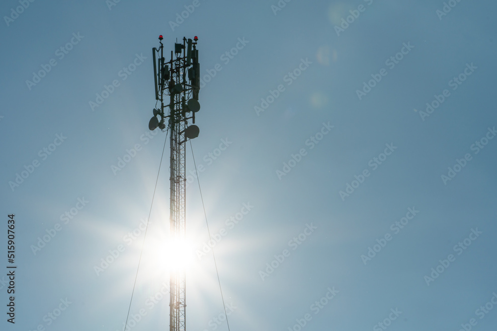 New GSM antennas on a high tower against a blue sky for transmitting a