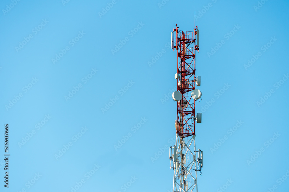 New GSM antennas on a high tower against a blue sky for transmitting a