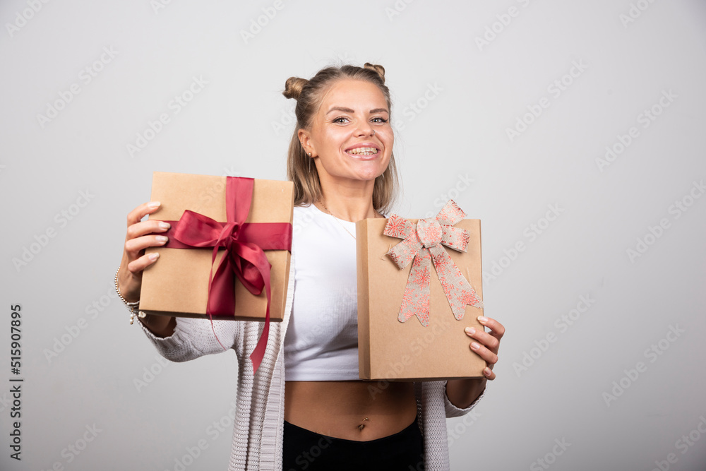 Smiling woman showing holiday gifts with happy expression Smiling woman showing holiday gifts with happy expression