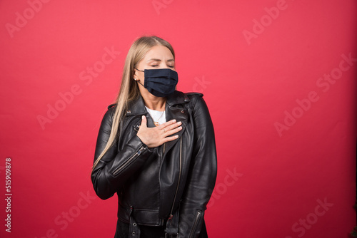 Beautiful young woman with a medical face mask pointing at herself