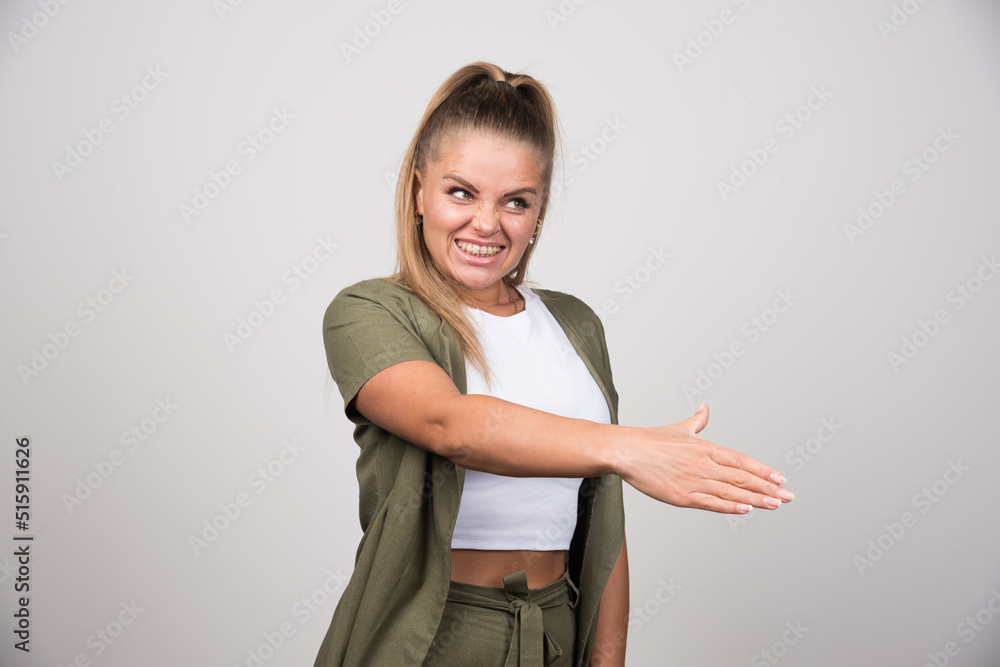 Young woman in green jacket offering her hand to shake Young woman in green jacket offering her hand to shake