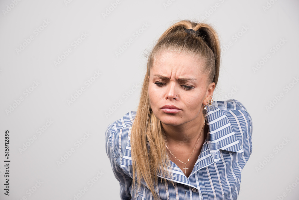 Woman in blue sweater posing on gray background Woman in blue sweater posing on gray background