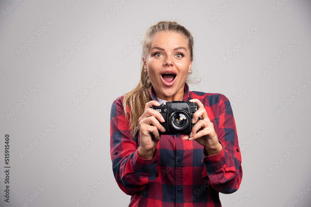 Blonde model in checked shirt looks positive and glamour while taking photos Blonde model in checked shirt looks positive and glamour while taking photos