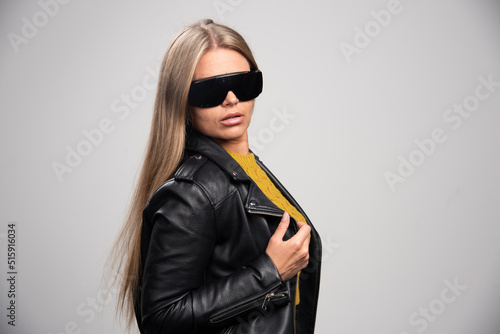 Blonde celebrity in black sunglasses looks confident and proud of herself