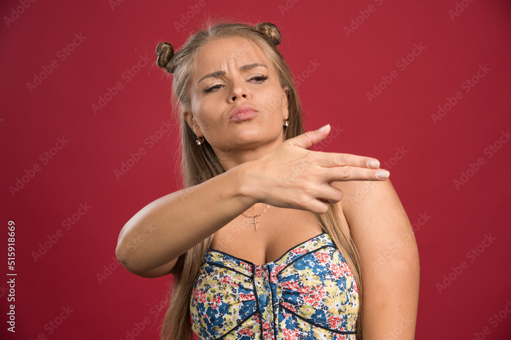 Pretty woman pointing her side on red background Pretty woman pointing her side on red background