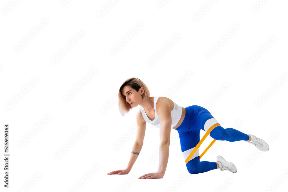 Sexy woman in sportswear using a resistance band in her exercise routine. Young woman performs fitness exercises on white background. Isolate Sexy woman in sportswear using a resistance band in her exercise routine. Young woman performs fitness exercises on white background. Isolate