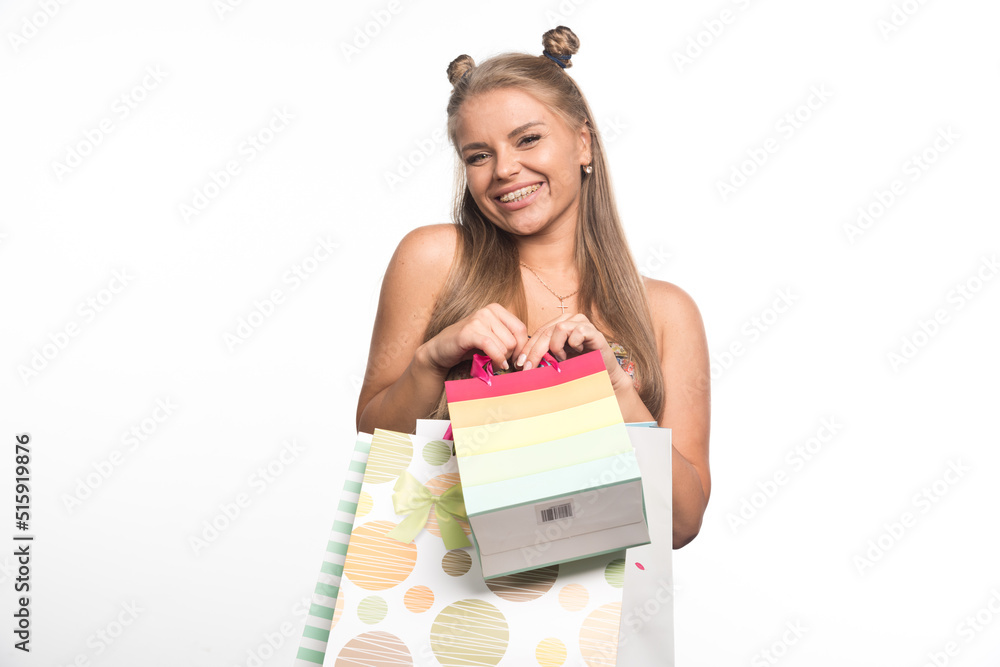 Blonde woman holding shopping bags on white background Blonde woman holding shopping bags on white background