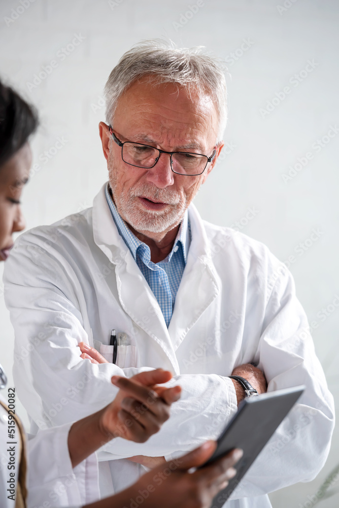 Male and female doctors consulting looking at a portable tablet computer Male and female doctors consulting looking at a portable tablet computer