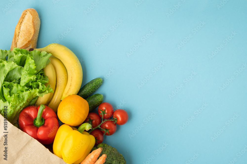Grocery brown paper bag full of fresh fruits and vegetables on blue ...