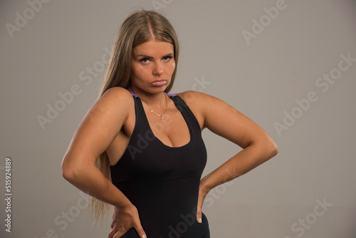 Female model in sport bra looks seductive with hands on the waist