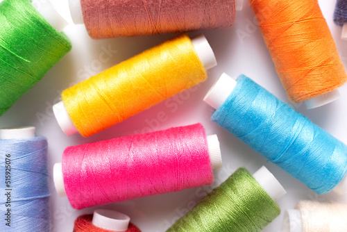 Bright sewing thread spool at white background, top view. Colorful spool with thread