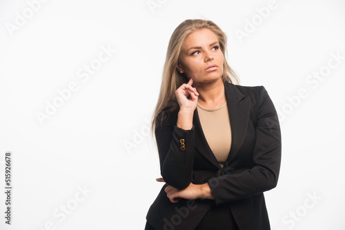 Young businesswoman in black suit looks focused