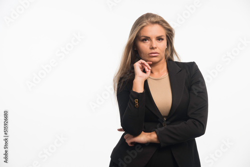 Young businesswoman in black suit looks dedicated