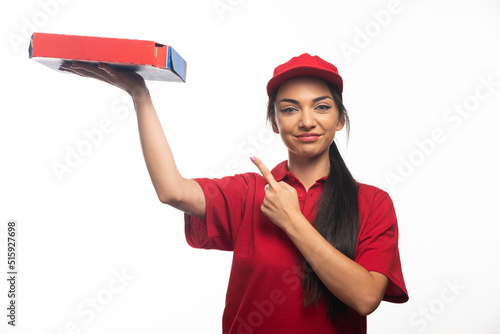 Delivery female employee in red cap holding a cardboards of pizza