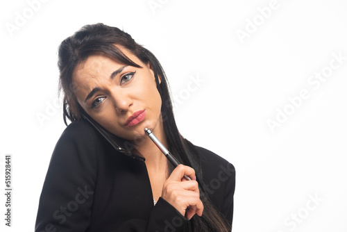 Business woman posing with pencil and cell phone on white background