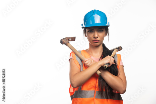 Fototapeta Woman wearing in vest and helmet holding hammers
