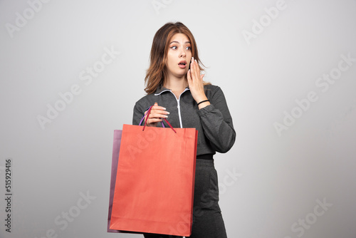 Photo of young woman holding shopping bags