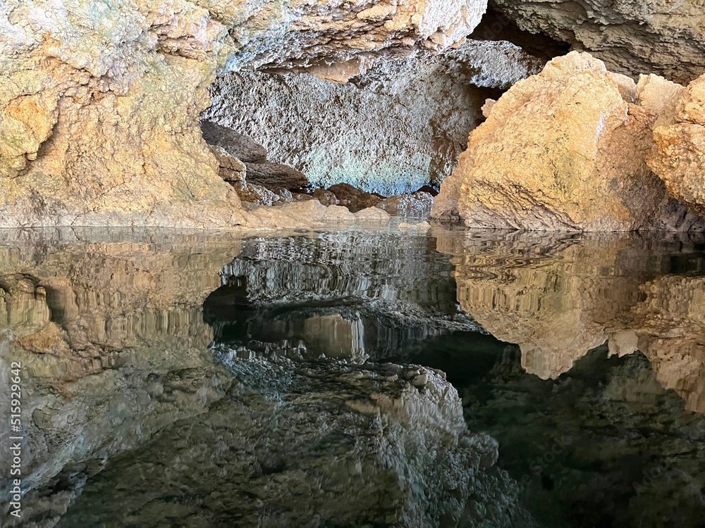 Rocks in the sea cave. Cave grotto with reflection of rocks in clear sea water.

