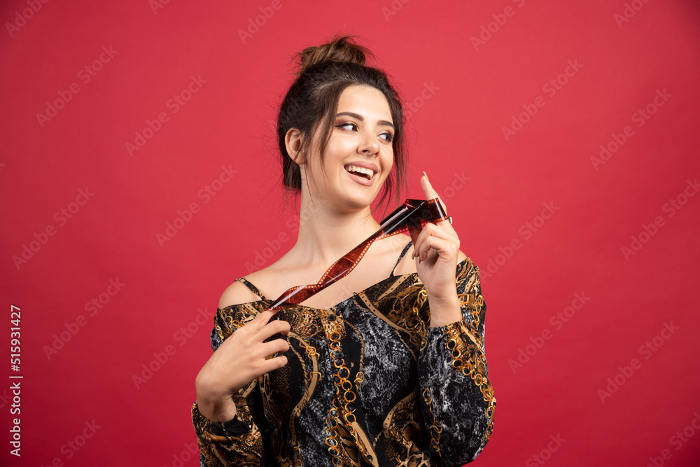 Brunette girl checks her photo history on polaroid film and looks satisfied Brunette girl checks her photo history on polaroid film and looks satisfied