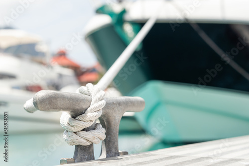 Mooring rope with a knot. Luxury yacht moored with a white rope to the pier in the marina photo