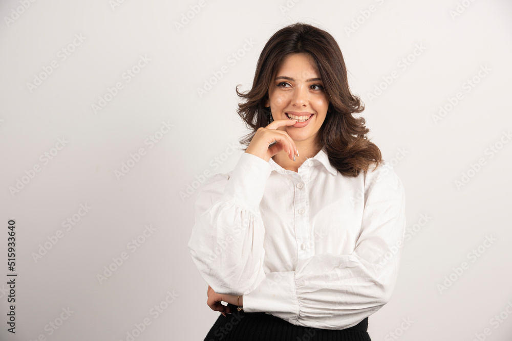 Young employee biting her finger on white background Young employee biting her finger on white background