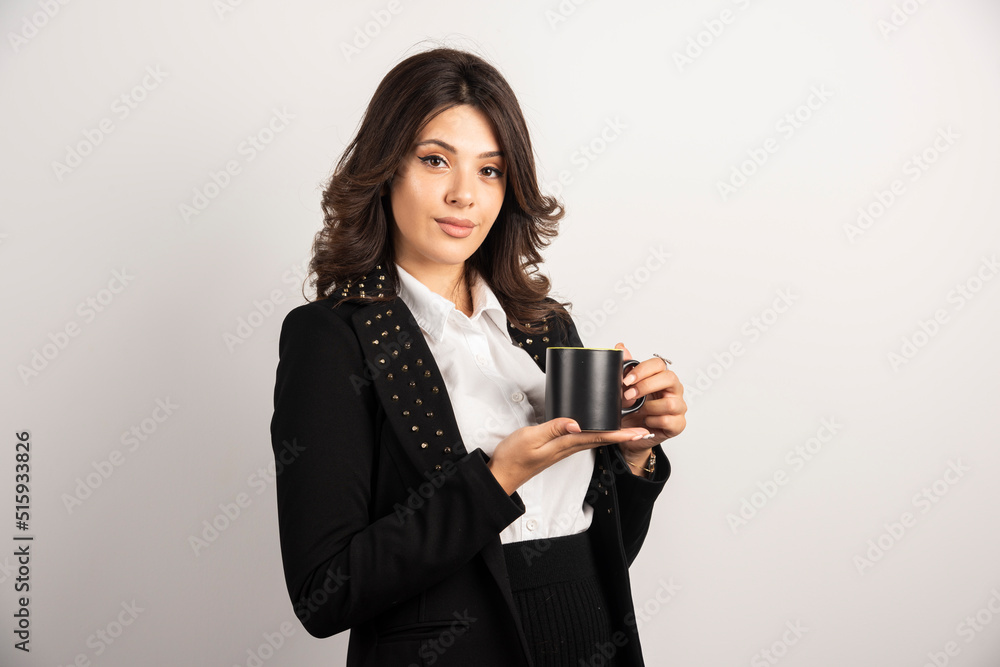 Businesswoman standing with cup of tea on white background Businesswoman standing with cup of tea on white background