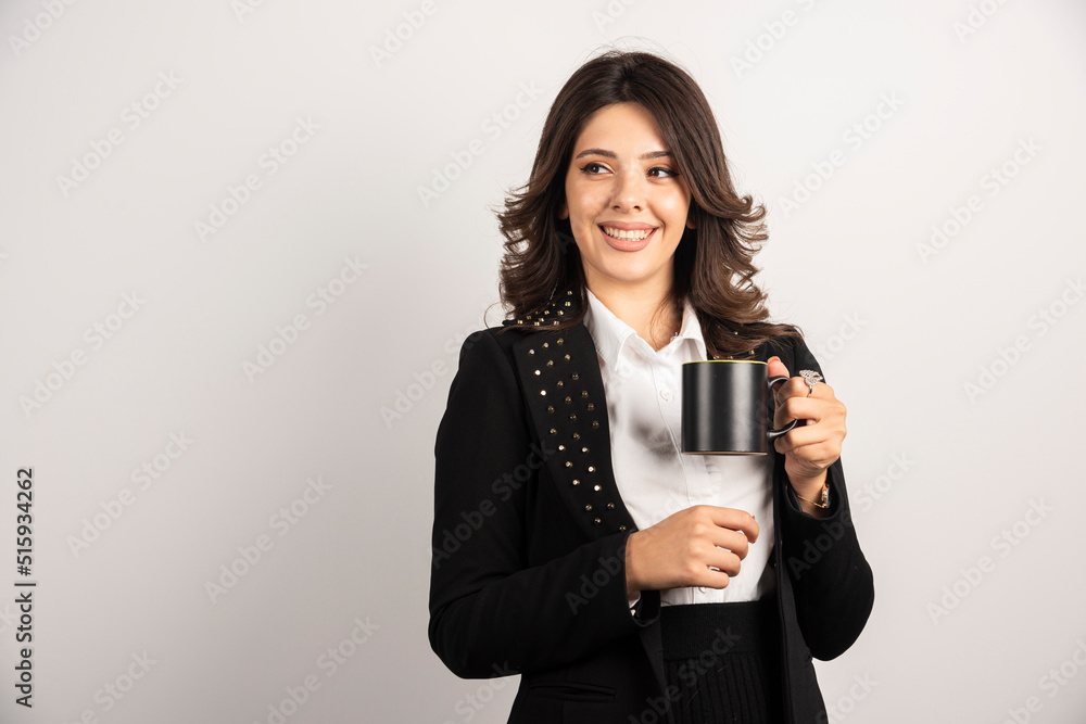Female worker holding tea with happy expression Female worker holding tea with happy expression