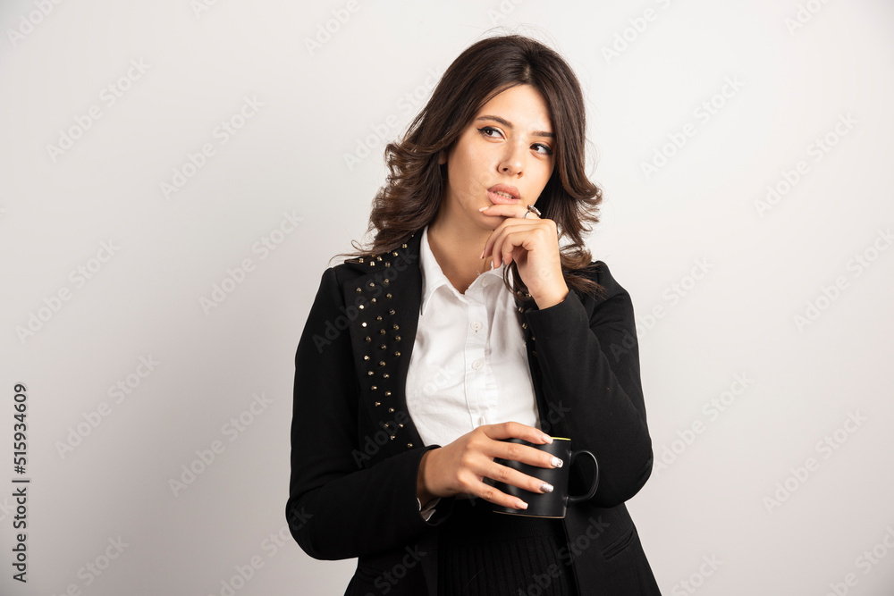 Female office worker posing with cup of tea on white background Female office worker posing with cup of tea on white background