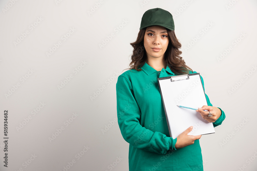 Delivery woman in green uniform showing order details Delivery woman in green uniform showing order details